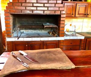 eine Küche mit einem gemauerten Kamin und einem Holztisch in der Unterkunft Mario Algarin in Puerto Iguazú