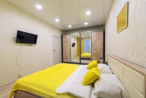 a bedroom with a large yellow bed and a mirror at SC Apart Ostrovskogo 93Б in Perm in Perm