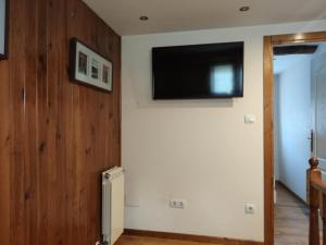 a room with a television on a wall with a radiator at Casa Fuente el vache in Campomanes