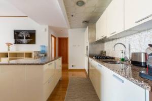 a kitchen with white cabinets and granite counter tops at Frank Porter - Mulberry 1 in Dubai