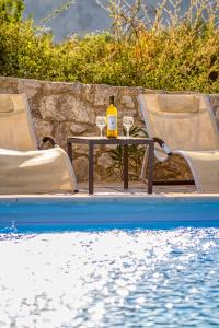 Una botella de vino sentada en una mesa junto a una piscina en Lake Villas en Mouríon