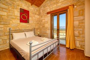 1 dormitorio con 1 cama en una pared de piedra en Lake Villas, en Mouríon