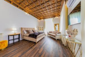 ein großes Wohnzimmer mit einem Bett und einem Sofa in der Unterkunft Palazzo Ardizzone in Palermo