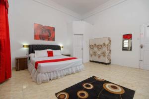 a bedroom with a bed with a red and white comforter at RedDoorz Syariah near Museum Tsunami Aceh 2 in Geutieue