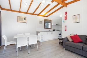 a living room with a table and a couch at Great Ocean Road Tourist Park in Peterborough