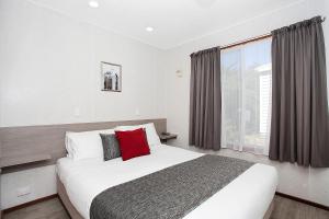 a bedroom with a large bed and a window at Great Ocean Road Tourist Park in Peterborough