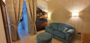 un soggiorno con divano blu e sedia di Hotel Classensis a Ravenna