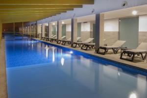 a pool with blue water in a building at Luna Hotel Serra da Estrela in Covilhã