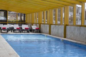 uma piscina com mesas e cadeiras em Luna Hotel Serra da Estrela na Covilh�