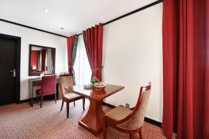 Manhattan Avenue Hotel في دبي: غرفة طعام مع طاولة وكراسي خشبية