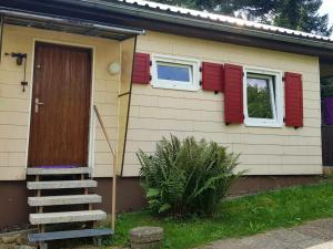 a house with red shuttered windows and a door at Charming Holiday Home in Liebenscheid by Forest in Liebenscheid