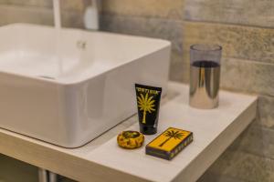 eine Badezimmertheke mit Waschbecken und Glas in der Unterkunft Palazzo Ardizzone in Palermo