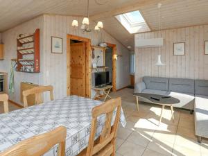 a dining room and living room with a table and a couch at Holiday home Farsø in Sundsøre