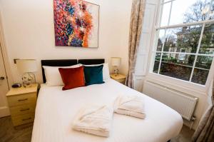 um quarto com uma cama branca e toalhas em Beaufort House Apartments from Your Stay Bristol em Bristol