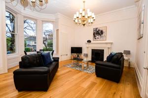 a living room with two chairs and a fireplace at Beaufort House Apartments from Your Stay Bristol in Bristol