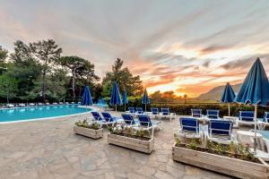 a group of chairs and umbrellas next to a pool at Montana Pine Resort - All Inclusive in Oludeniz