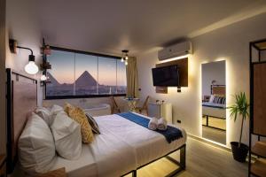 um quarto com uma cama e vista para as pirâmides em Jacuzzi By The Historic Giza Pyramids - Apartment 3 no Cairo
