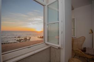 ポルトにあるLiiiving in Porto - Luxury Beachfront Apartmentsのビーチの景色を望む窓付きの客室です。