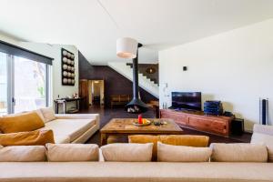 Ferragudo Premium Villa - heatable pool & river views في فيريغودو: غرفة معيشة مع أريكة وطاولة