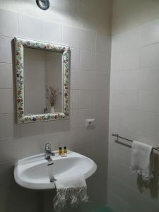 a white bathroom with a sink and a mirror at Castello di Pratelli in Incisa in Valdarno
