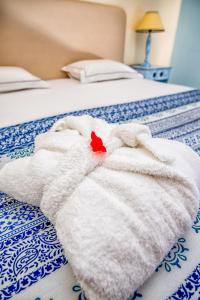 
a stuffed animal on a white blanket on a bed at Hotel Burgau Turismo de Natureza in Burgau
