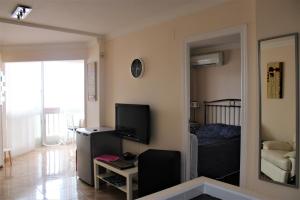 un salon avec une télévision et une chambre dans l'établissement Piso con vistas al mar El Campello, à El Campello