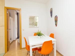 a dining room with a white table and orange chairs at Apartment Eixample Dret Sagrada Familia by Interhome in Barcelona