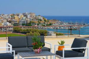 two chairs and a table on a balcony with a harbor at Gargadoros House in Agios Nikolaos