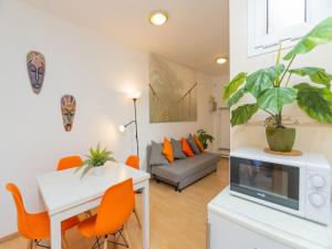sala de estar con mesa blanca y sillas naranjas en Apartment Eixample Dret Sagrada Familia by Interhome, en Barcelona