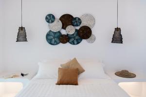 a bedroom with a white bed with blue plates on the wall at Zefi Hotel & Suites in Naousa