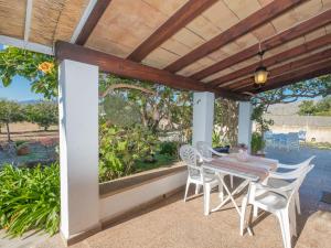 a patio with a table and chairs under a wooden pergola at Holiday Home Can Niu by Interhome in Pollença