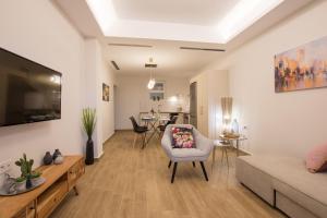 a living room with a couch and a tv at B4B Sea n' City in Zakynthos Town