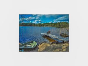 una barca sulla riva di un lago con panchina di Holiday Home Lauttavalkama by Interhome a Torvoila