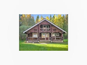 a large wooden house with trees in the background at Holiday Home Karhunluola by Interhome in Hauho