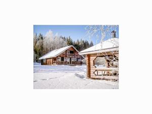a log cabin in the snow next to a building at Holiday Home Karhunluola by Interhome in Hauho