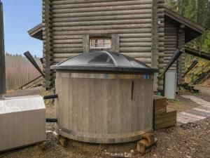 a trash can in front of a log cabin at Holiday Home Härkälinna by Interhome in Hauho