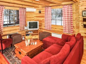 a living room with red couches and a tv at Holiday Home Puolukka by Interhome in Hauho