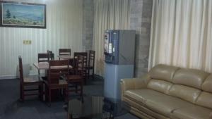 sala de estar con sofá, mesa y nevera en Nuevo Hotel Alameda de Uruapan, en Uruapan del Progreso