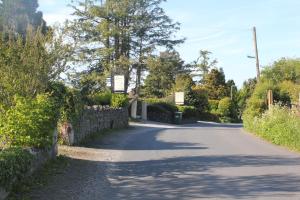 un camino sinuoso con una pared de piedra y árboles en Lakeside Lodge, en Bassenthwaite Lake