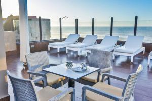 a patio with chairs and tables and the beach at Riad Mimouna in Essaouira