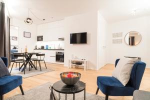 Luxury Suites Renngasse في فيينا: غرفة معيشة مع كراسي زرقاء وطاولة