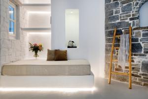 a bed in a room with a brick wall at Zefi Hotel & Suites in Naousa