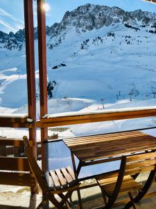 a wooden bench sitting on top of a snow covered mountain at Résidence Bero Bisto in La Mongie