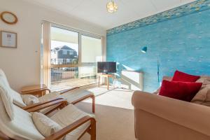 a living room with a couch and a tv at 12 Westward Flats in Polzeath