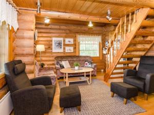 a log cabin living room with a table and chairs at Holiday Home Savilahti by Interhome in Ahmovaara