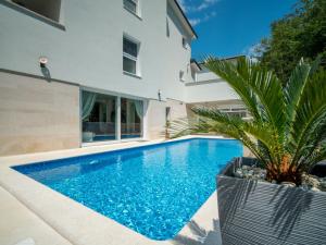 a swimming pool in front of a house at Holiday Home Anđela by Interhome in Dobrinj
