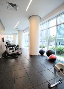 a gym with exercise equipment in a large room with windows at H Luxury Apartment at Surfers Paradise High floor in Gold Coast