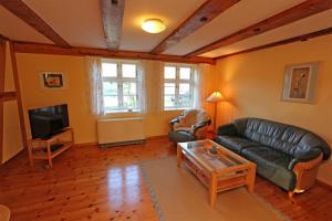 ein Wohnzimmer mit einem Ledersofa und einem TV in der Unterkunft Ferienhaus mit 3 Schlafräumen Neu Sommersdorf SCHW 891 in Sommersdorf