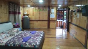 - une chambre avec un lit dans une pièce dotée de murs en bois dans l'établissement Challet Tualang, à Kota Bharu