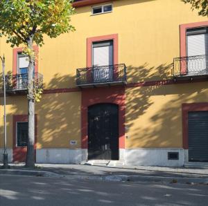 een geel en rood gebouw met een deur en een balkon bij Palazzo Salvi in Telese
